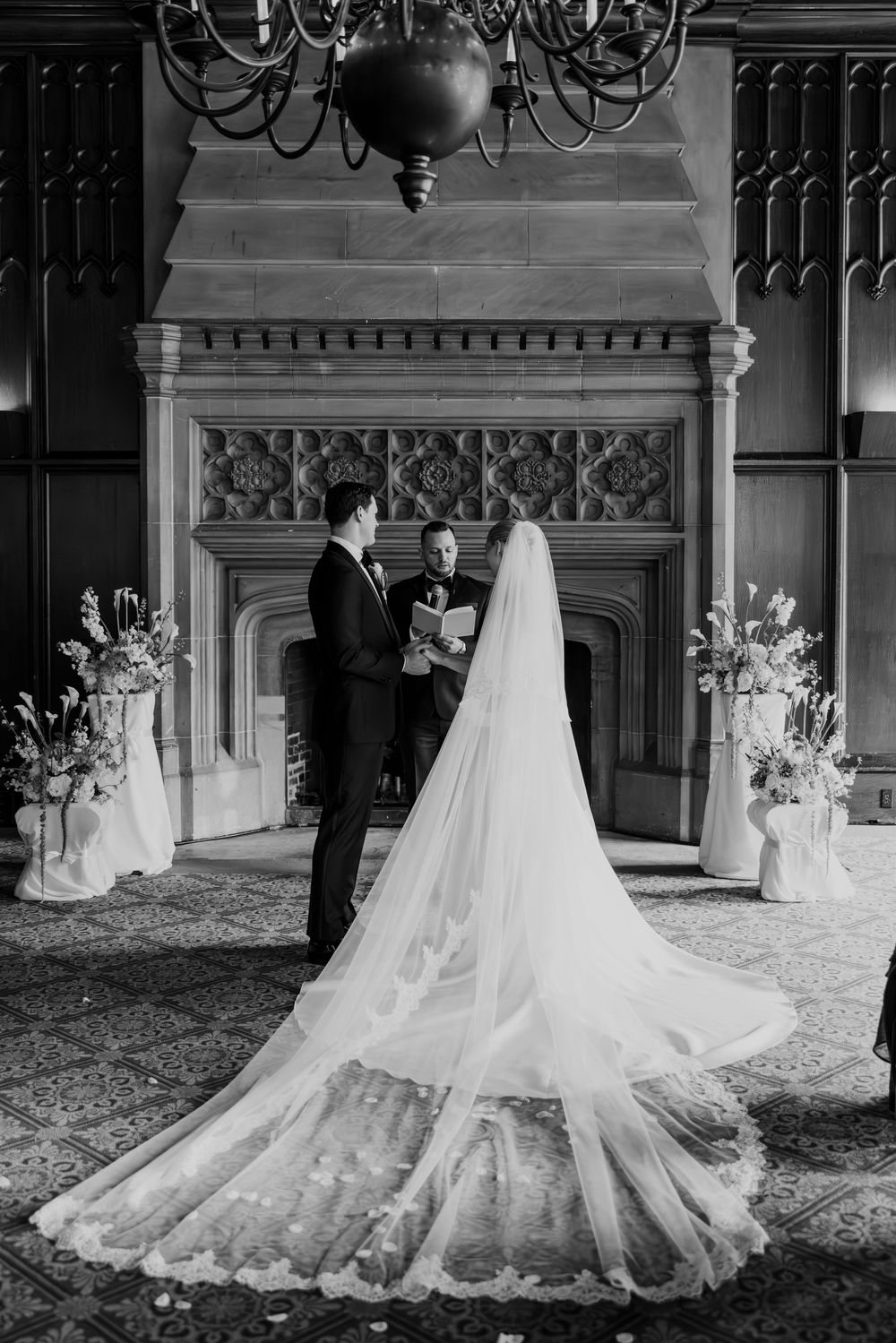 A series of black and white photos showing a flowing wedding dress with a long cathedral veil displayed in an elegant room.