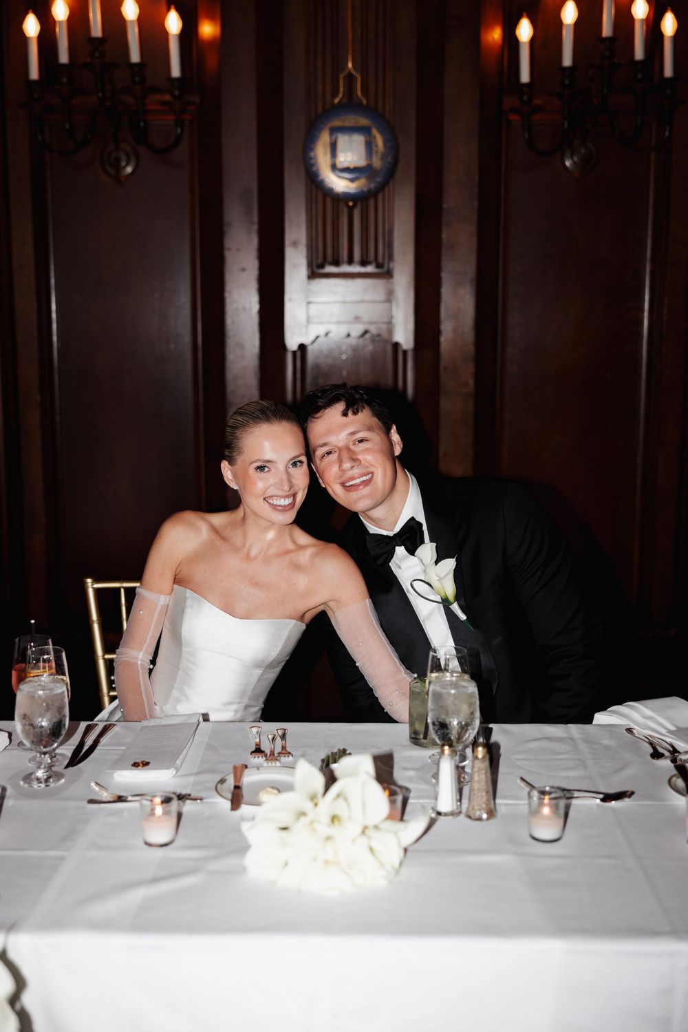 A series of candid reception photos showing a couple at their wedding dinner table with romantic candlelight ambiance.