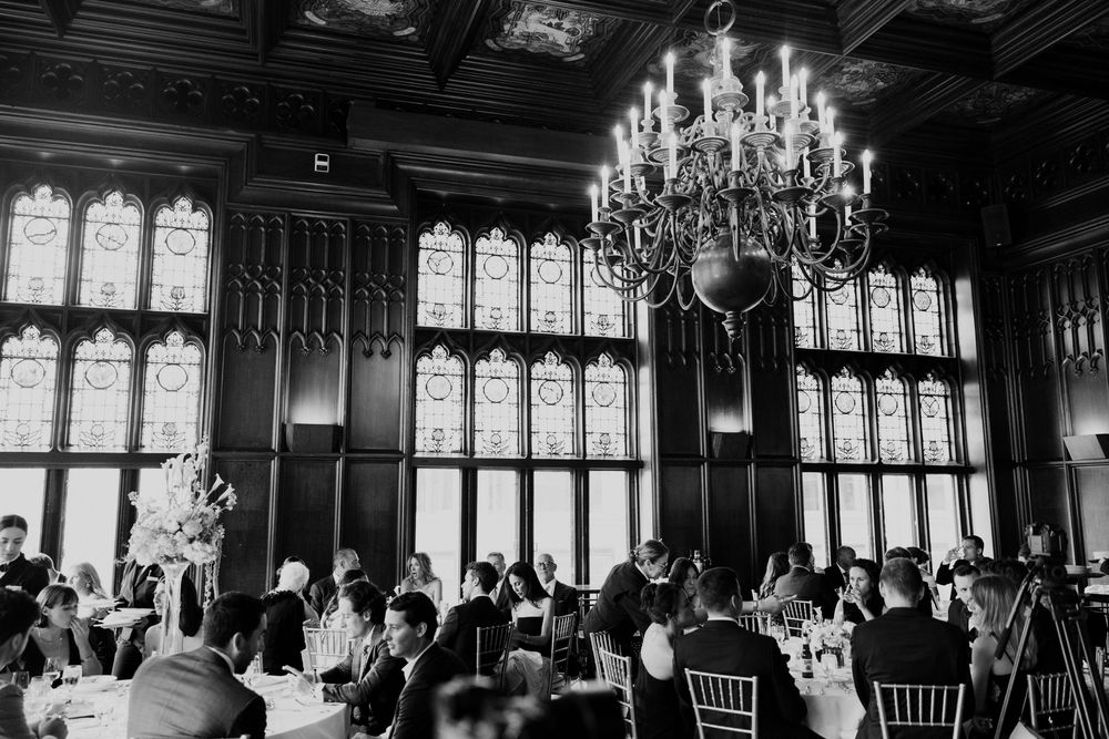 Elegant black and white panorama of a grand ballroom with chandeliers and Gothic windows during Chicago wedding.