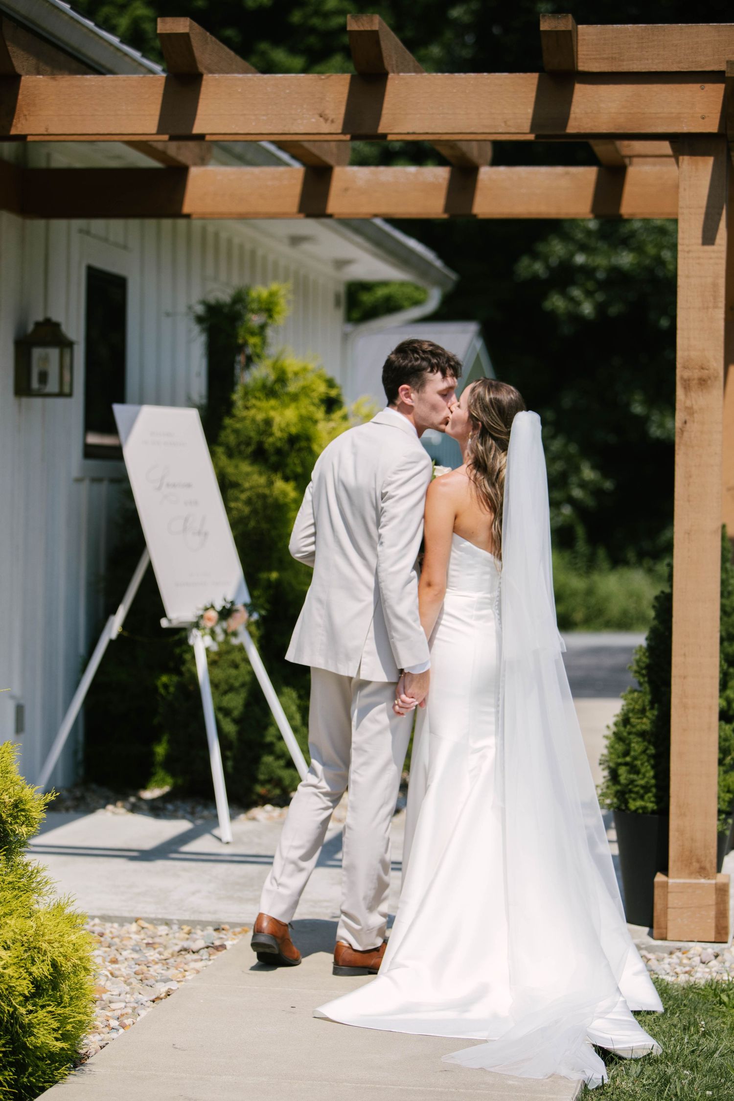 A romantic wedding portrait of a couple in white dress and black tuxedo sharing an intimate moment.
