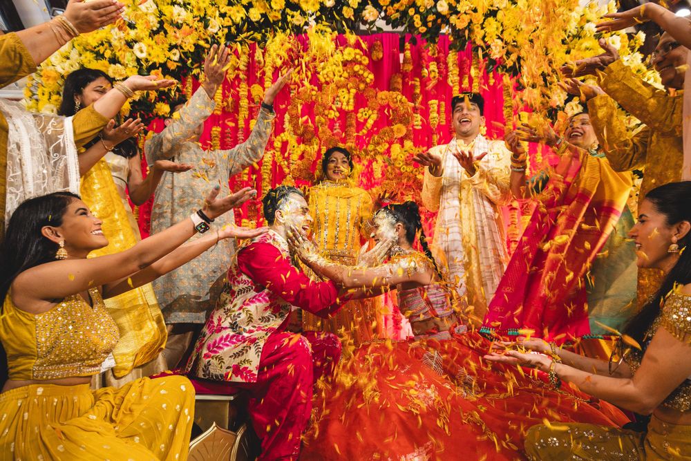 Traditional Indian Haldi ceremony with yellow turmeric powder being thrown in celebration.