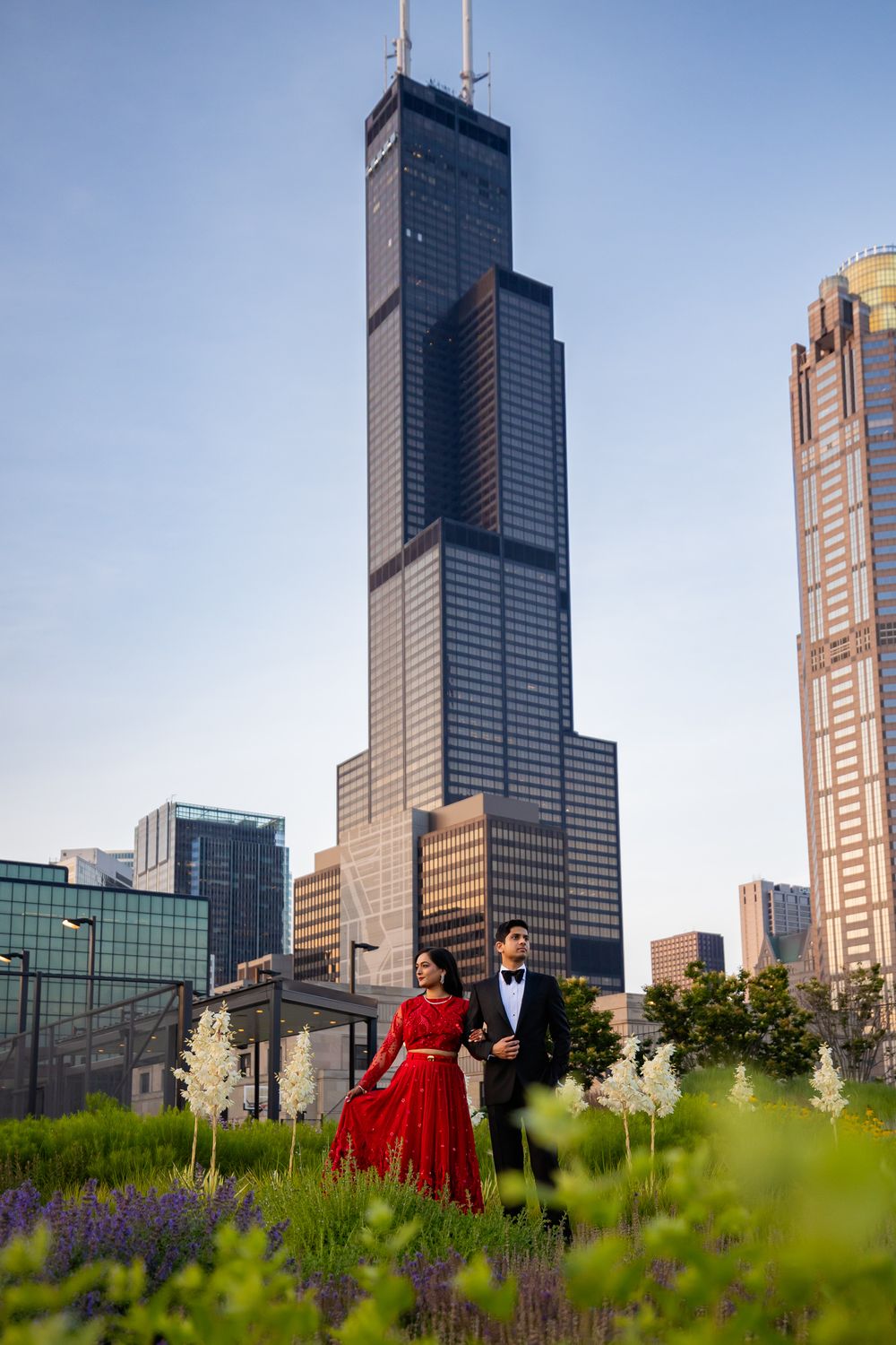 Chicago skyline towers over a lush garden with purple wildflowers in the foreground at Lurie Garden.