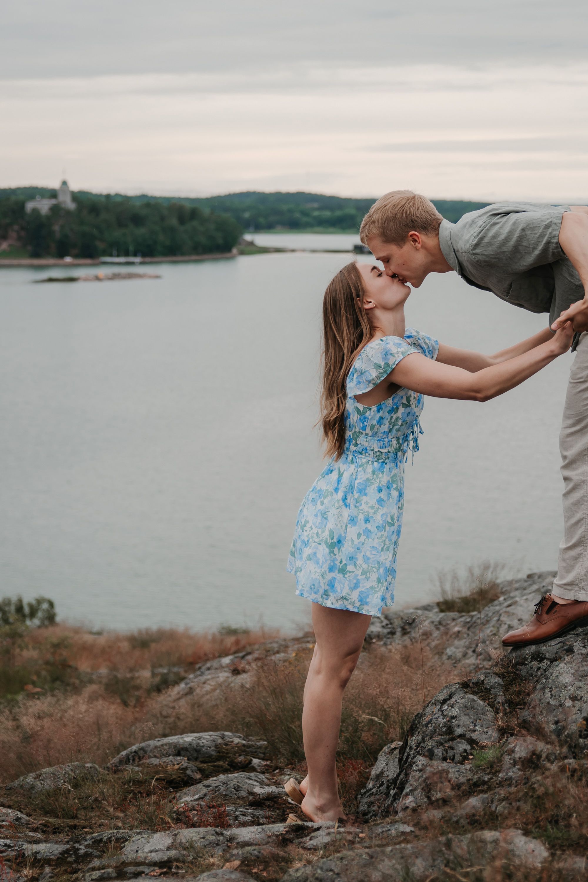 Couple in white and grey clothing sharing intimate moment while holding hands.