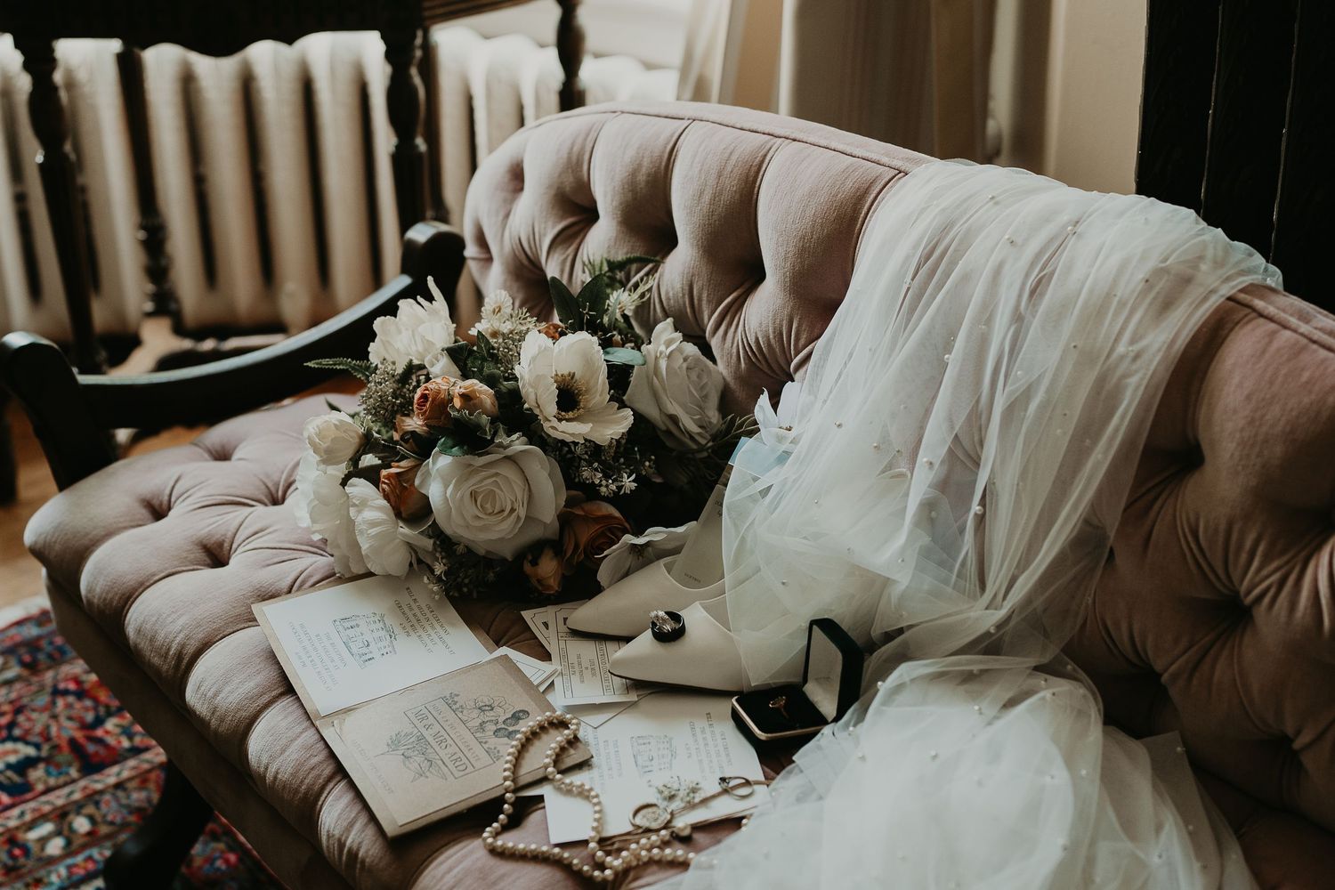 a vintage rose couch with wedding details lying on it.