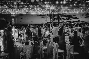 A black and white photo montage of a wedding reception showing guests dancing and celebrating on the dance floor.
