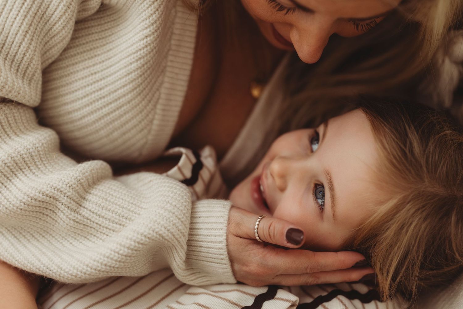 Sweet embrace captured in soft lighting outdoors.