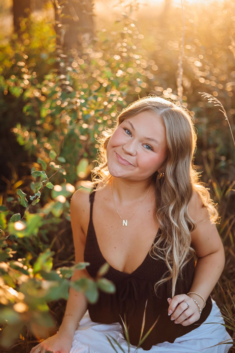Golden hour portrait session among autumn foliage with warm backlighting. Senior photography