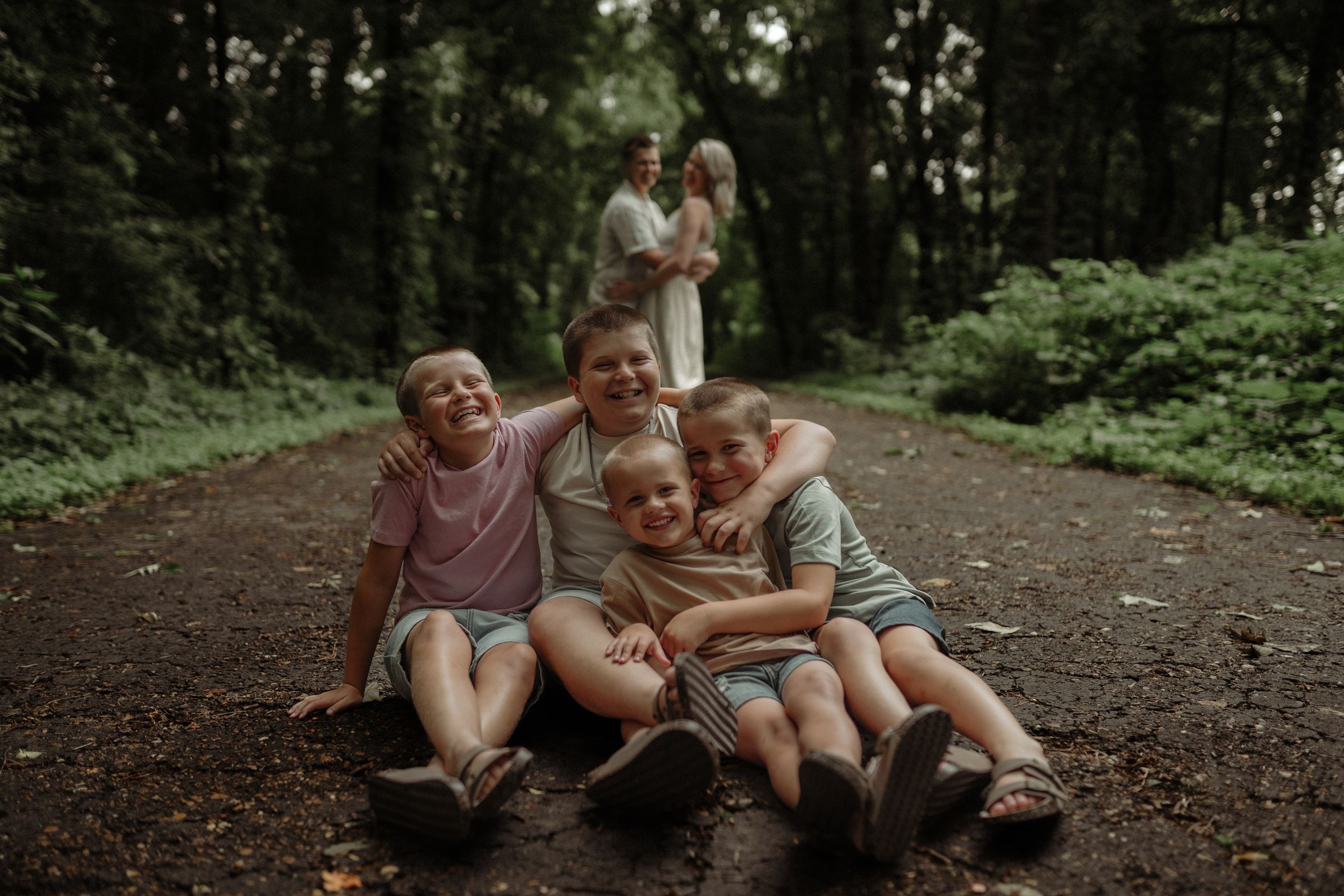 A joyful outdoor family moment captured on a forest path.