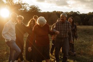 Group walking together through a field at golden hour with sun flare.