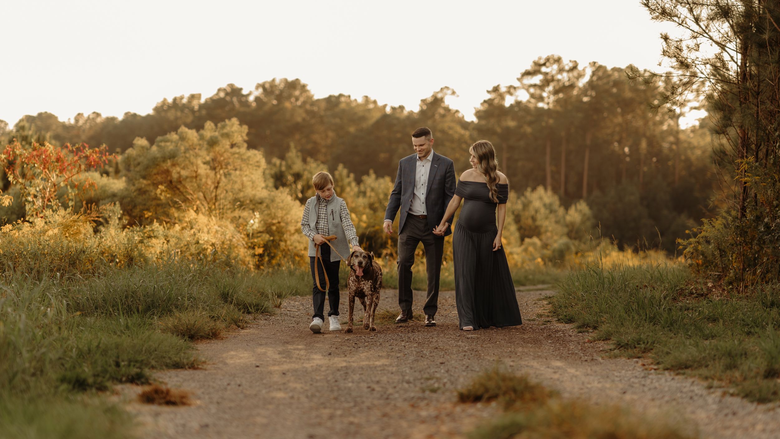 Group walking together on a scenic dirt path during golden hour.