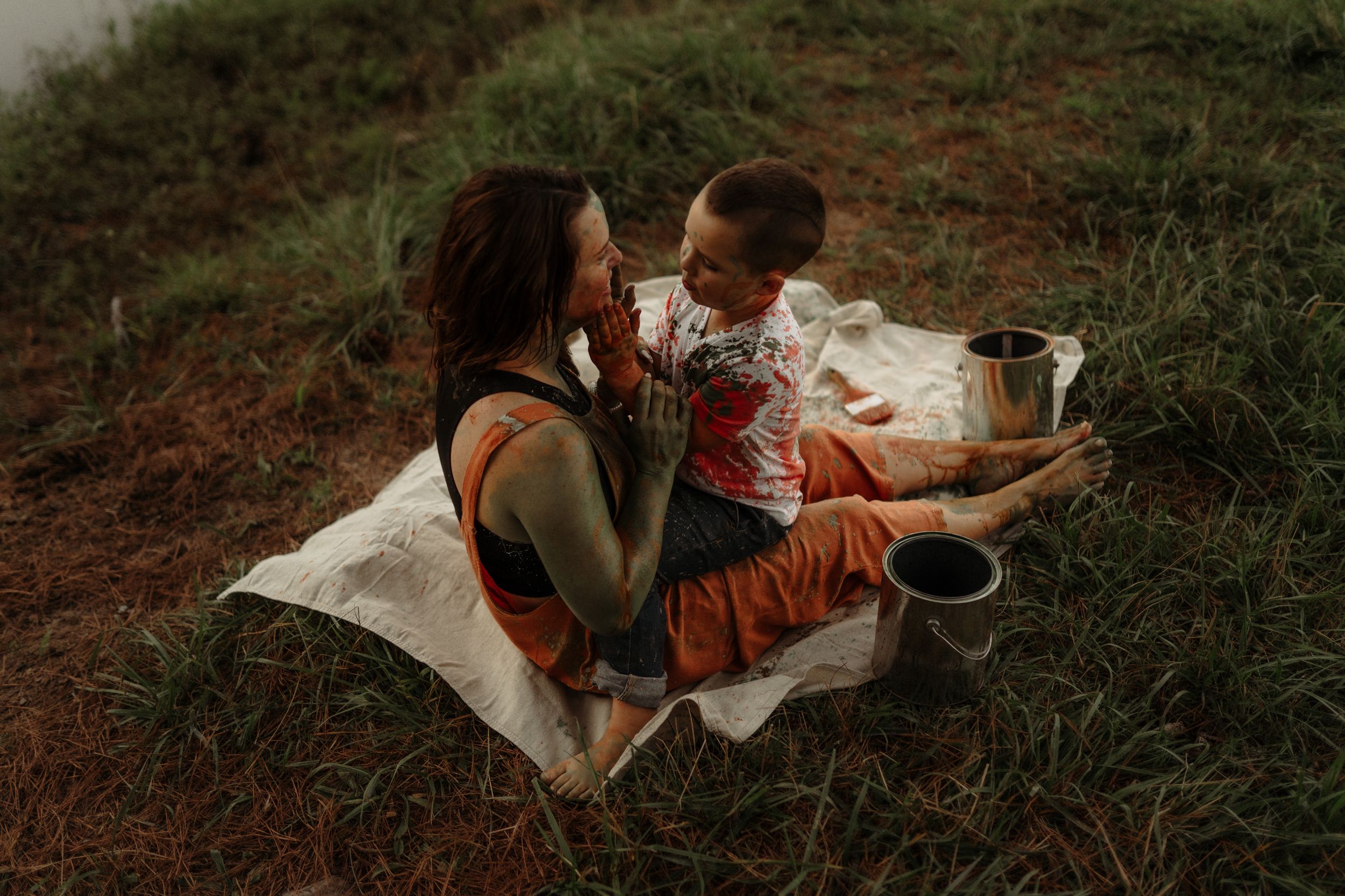 Family relaxing on blanket during intimate outdoor photoshoot.