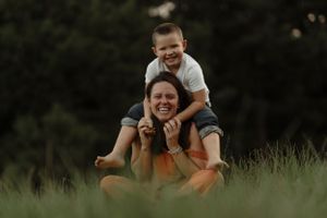 Playful moments captured on grass during outdoor family photography session.