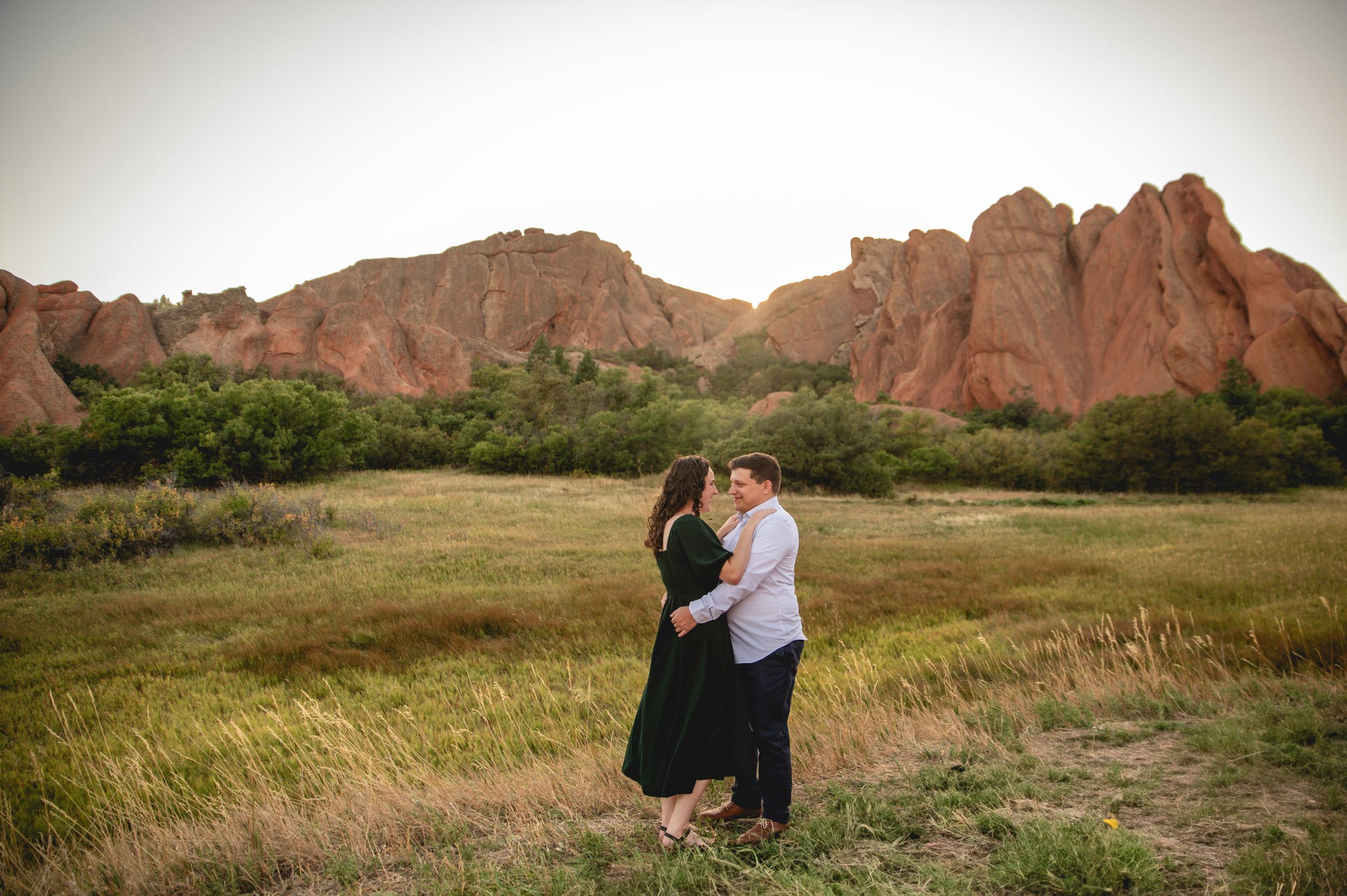 A romantic embrace against dramatic red rock formations at Garden of the Gods.