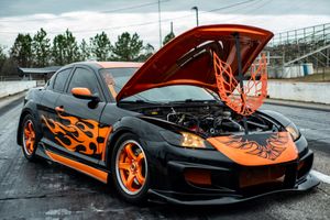 Custom McLaren P1 supercar showcasing striking black and orange color scheme with flame-inspired graphics on display.
