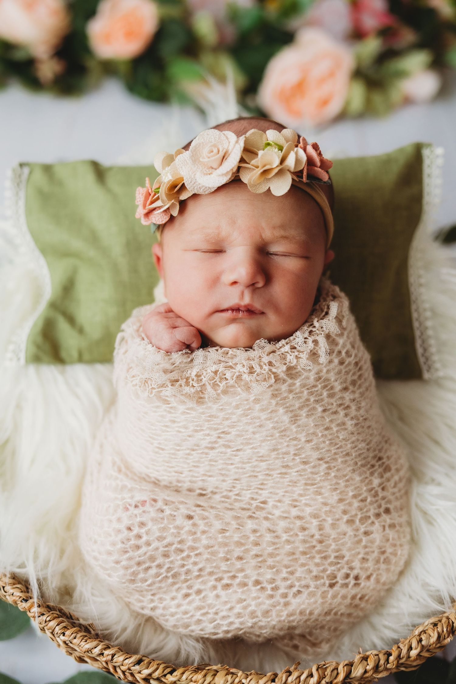 A sleeping newborn wearing a cozy brown bear outfit rests on soft fur.
