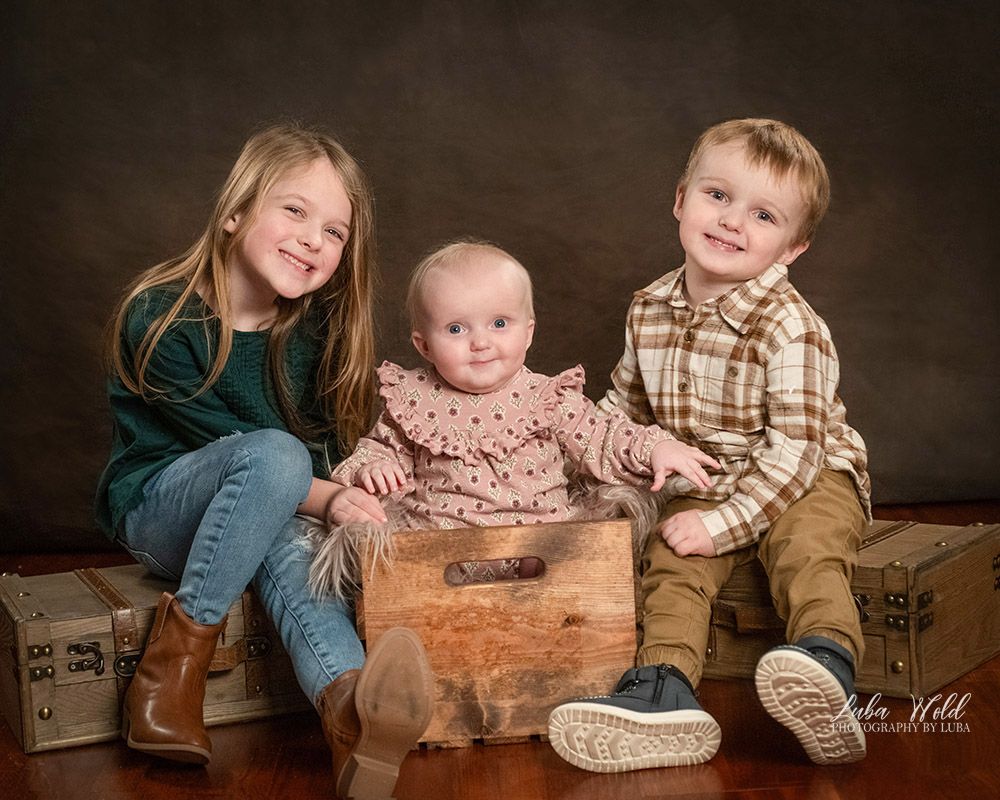 studio portrait of 3 siblings brother big sister and a baby girl by family photographer Luba Wold in Post Falls Idaho