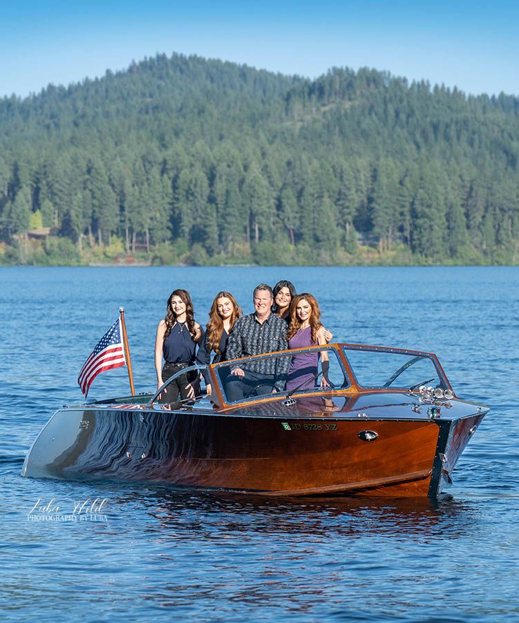 Portrait of Coeur d Alene family of five in a wood boat on the lake by photographer Luba Wold