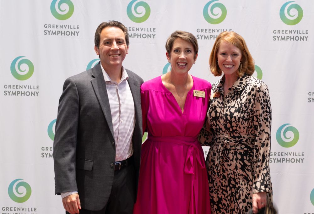 Three attendees stand together at a Greenville Symphony function.