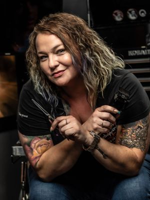 A series of photos showing someone in a black top posing with a tattoo sleeve against a dark background.