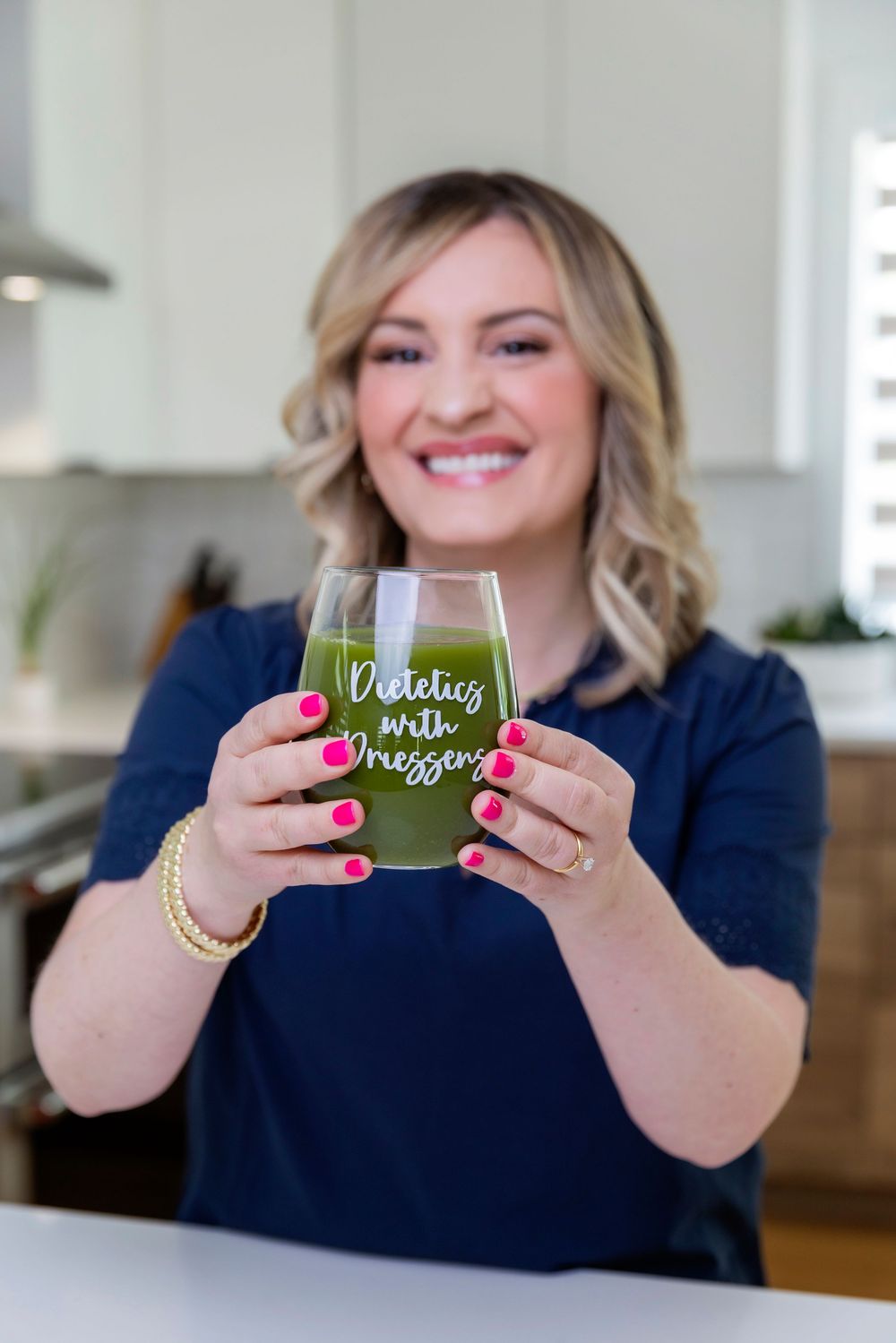 Person in navy blue shirt holds up green beverage glass showing progression of drinking stages in four photos.