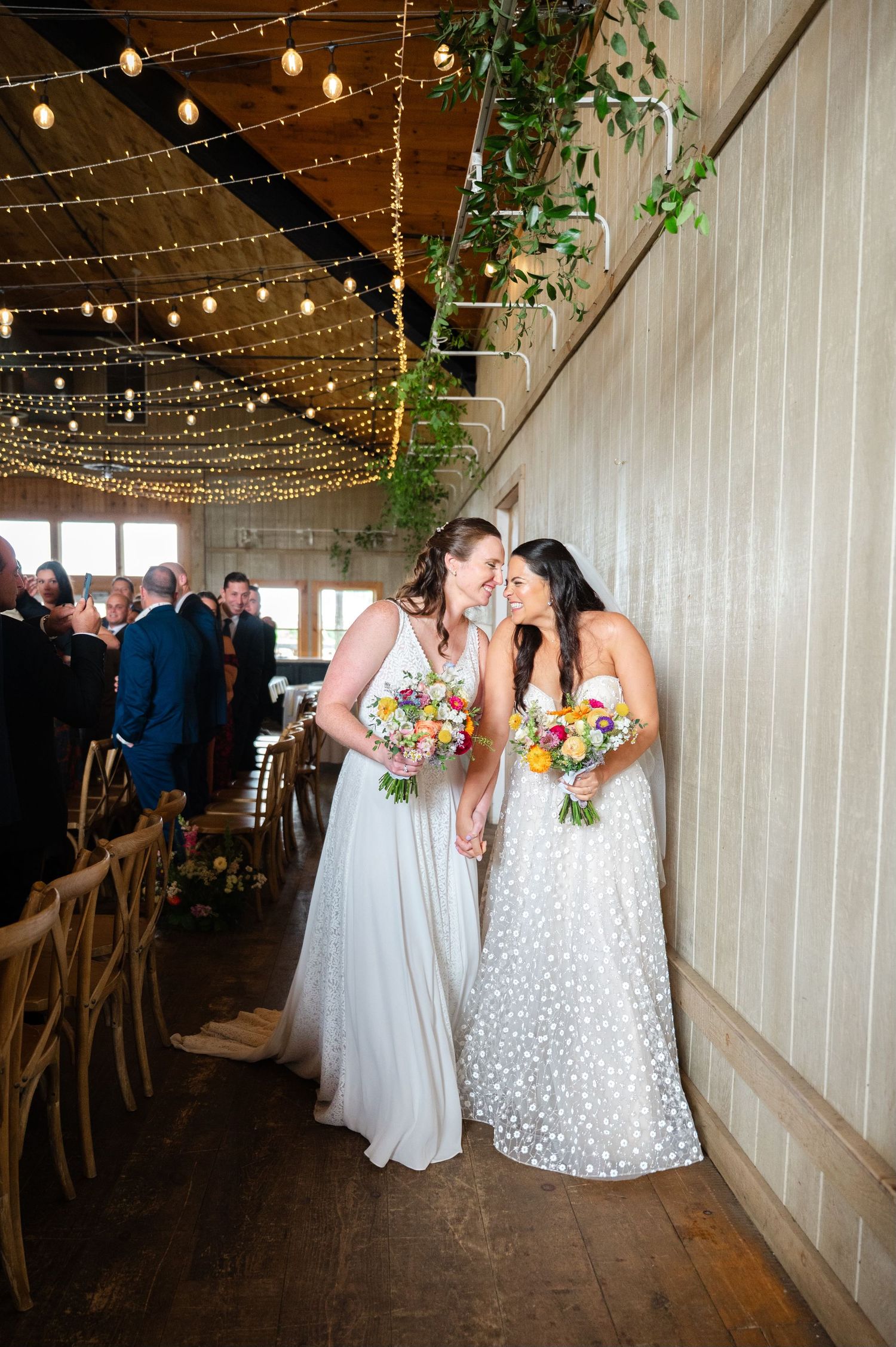 Couple shares joyful moment against rustic stone wall backdrop.