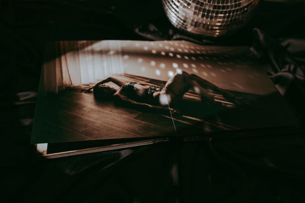 Prachtige fotoalbum met een foto in boudoirstijl en een discobal als decoratie