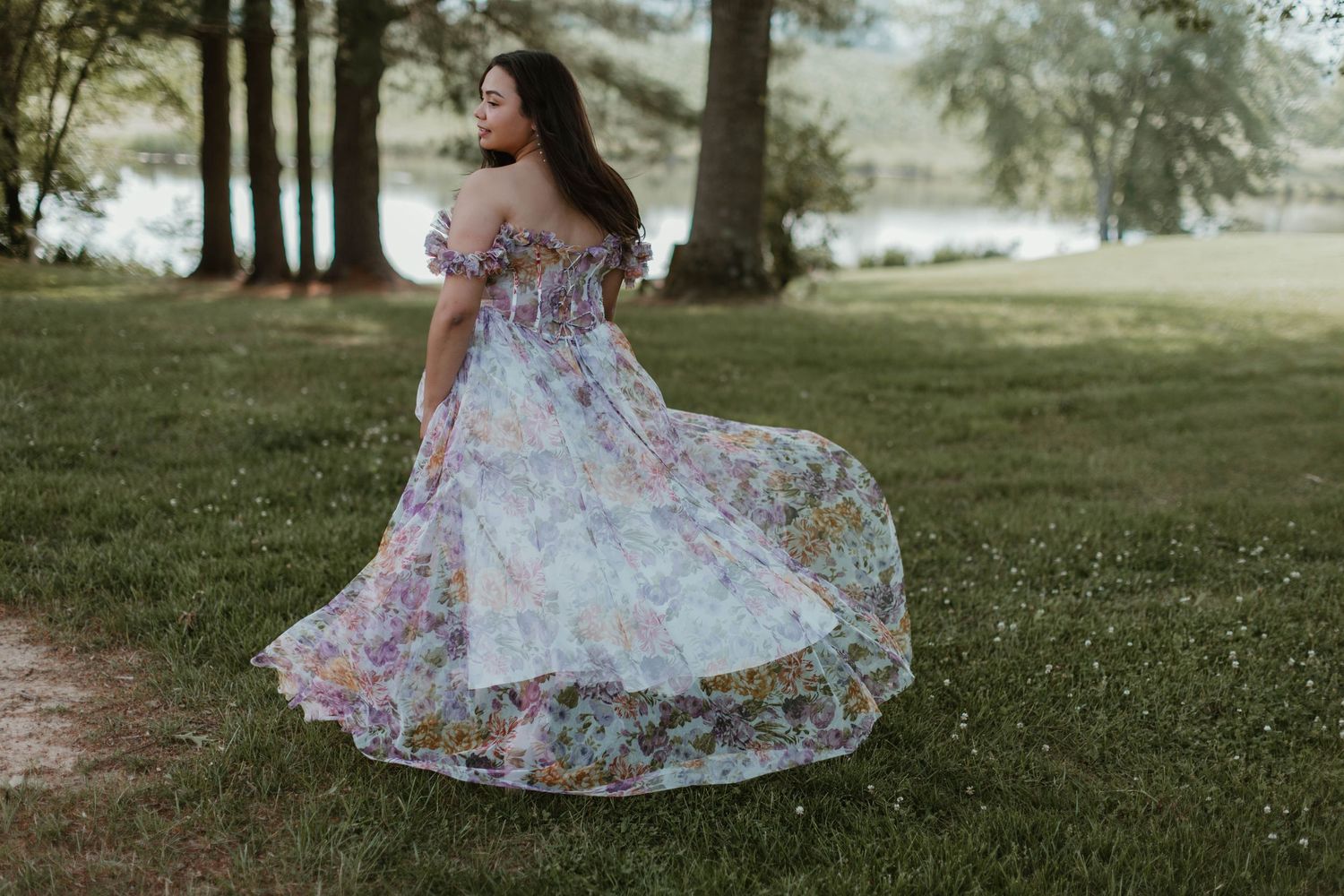 A floral dress flows elegantly in the breeze on a sunny lawn.