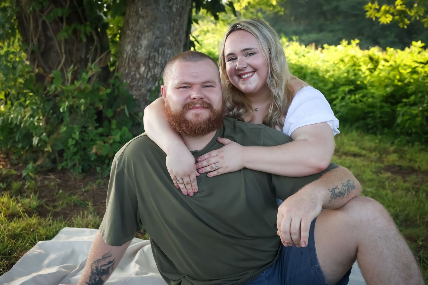 Outdoor couples portrait session in dappled sunlight against natural greenery.