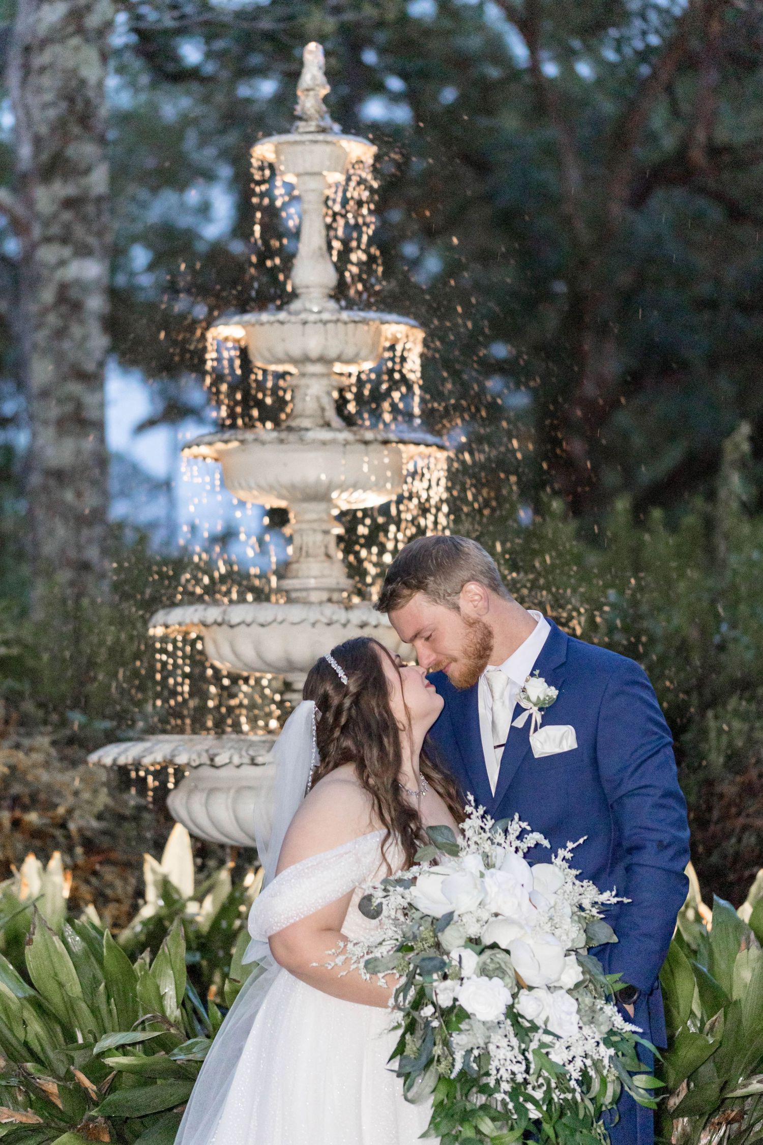 bride and groom in front of a fountain