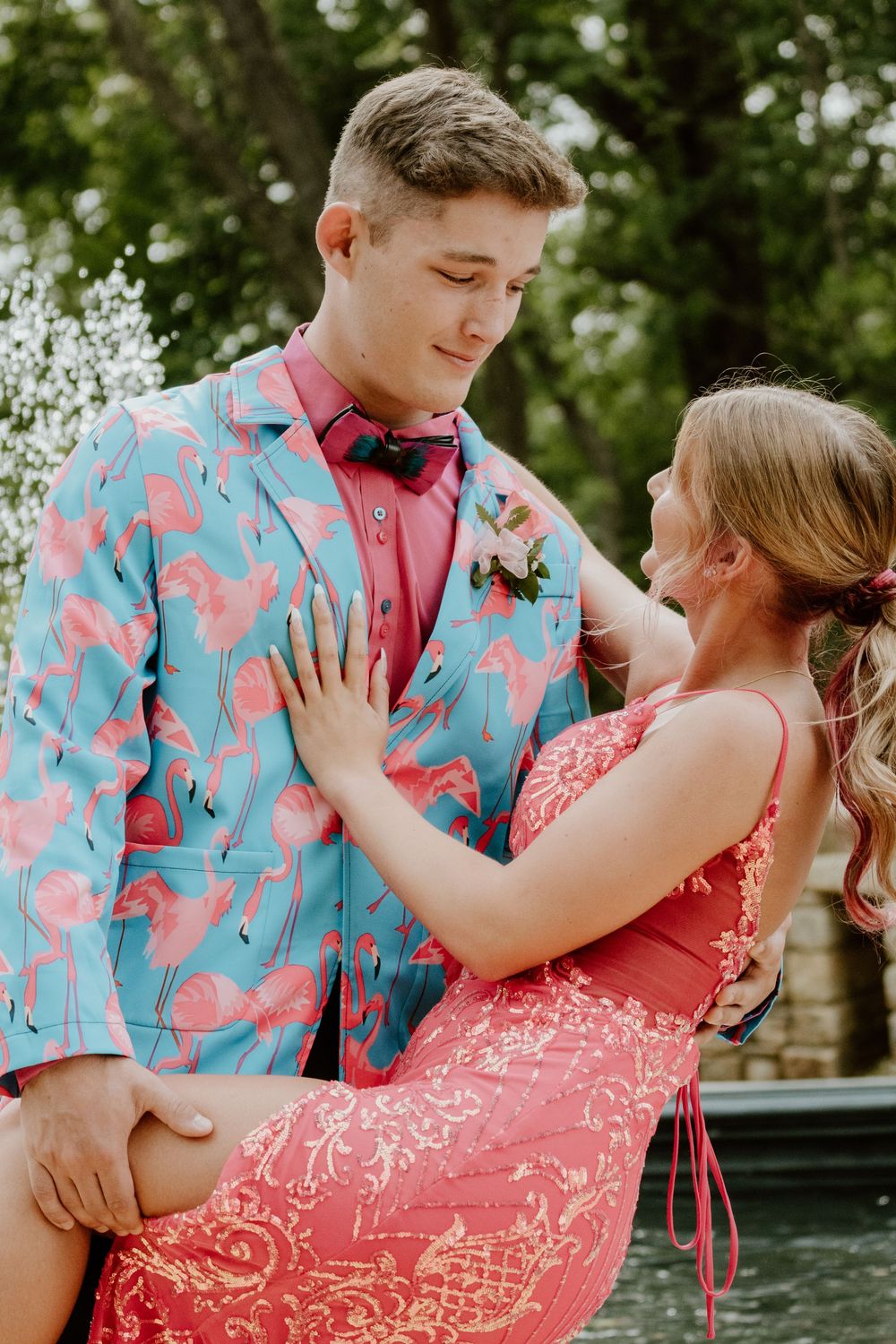 Couple in matching coral and blue patterned outfits embrace outdoors.