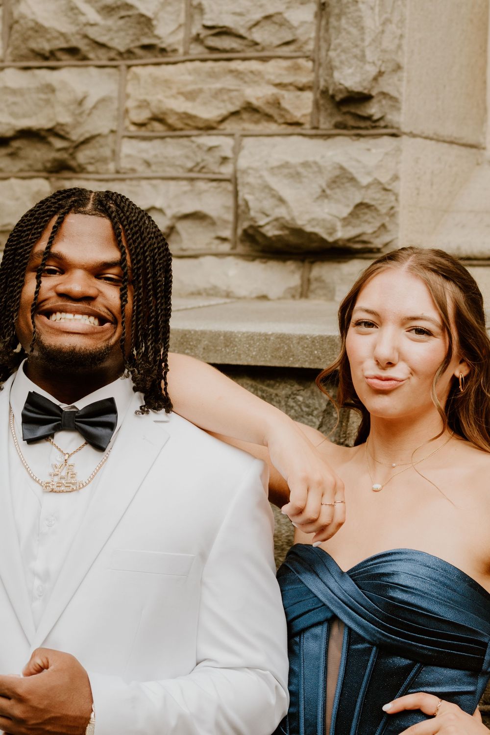 Close-up portraits of wedding party members in formal attire against stone wall.