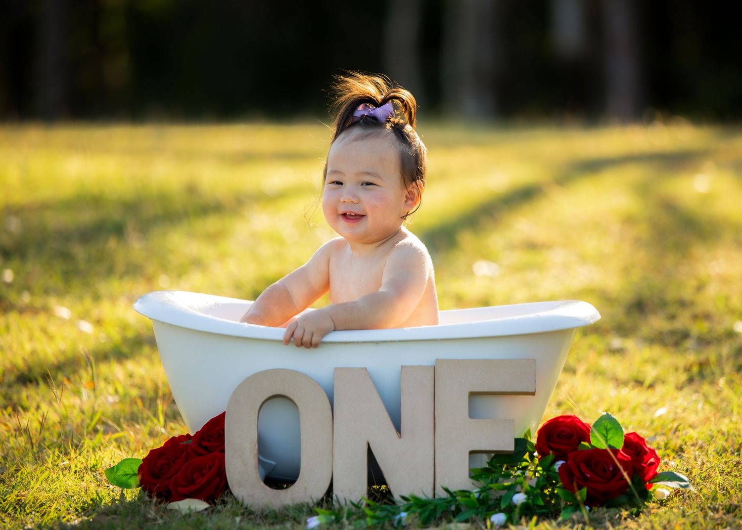 A small baby sits in an outdoor bathtub for first birthday photos. Professional Baby photographer, Townsville, QLD, Australia