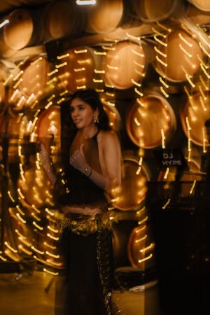 A dancer performs in front of swirling golden lights creating a magical nighttime atmosphere.