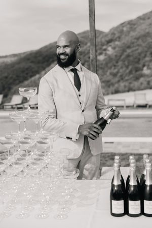 A champagne tower setup at an outdoor reception with bottles and glasses arranged elegantly.