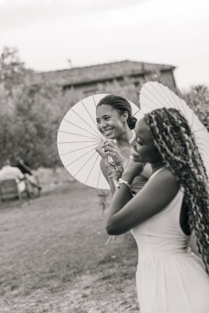 Black and white photo sequence showing joyful moments with a white paper parasol outdoors in a natural setting.