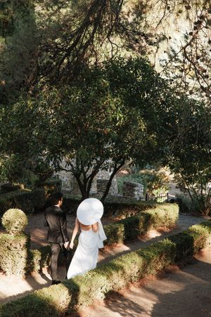 A series of photos showing someone in a white hat walking along a shaded garden path under trees and greenery.