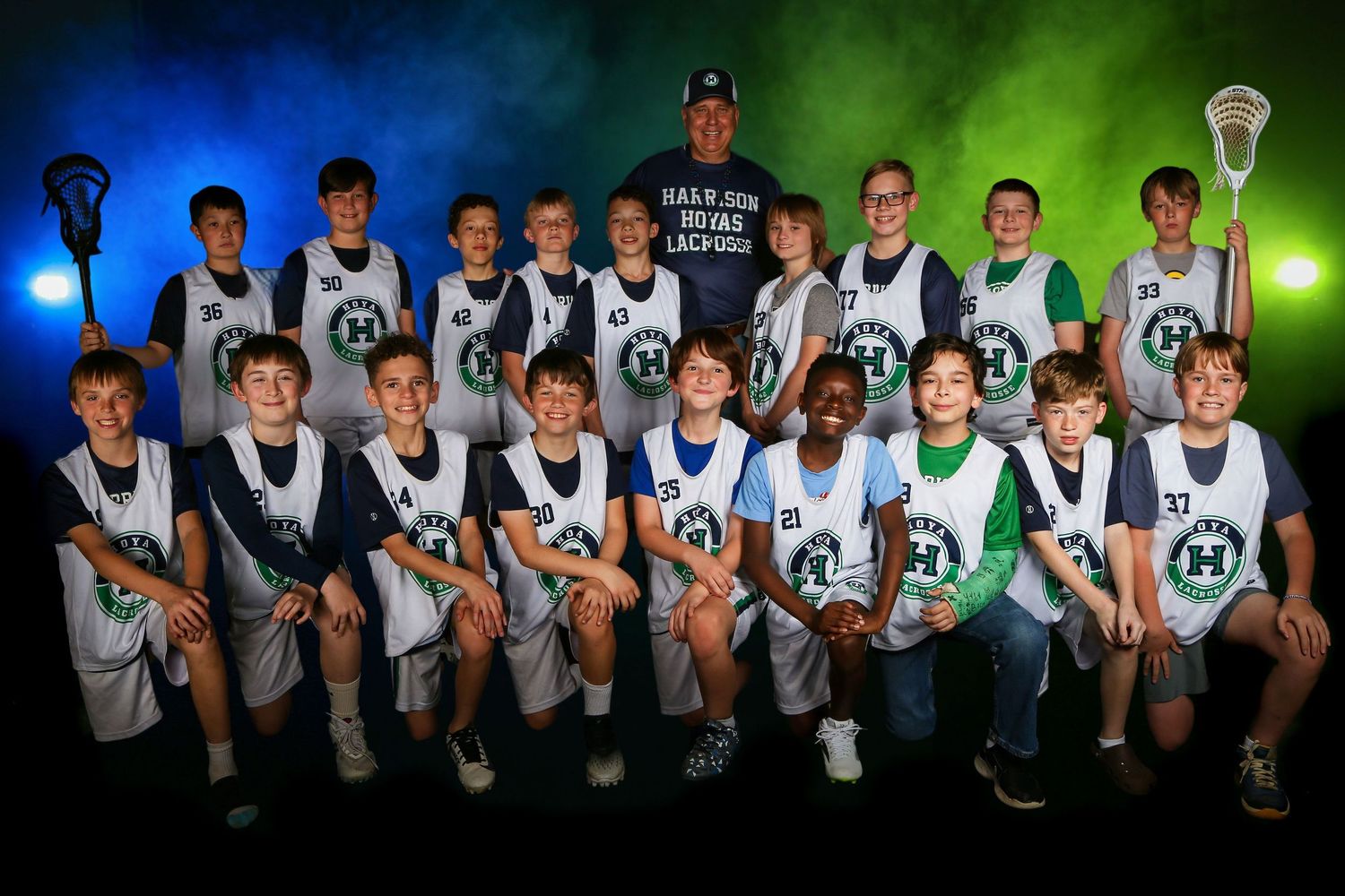 Dramatic lacrosse sports portrait, featuring colored gel lighting and smoke effects for bold, high-impact look. Boys elementary school team
