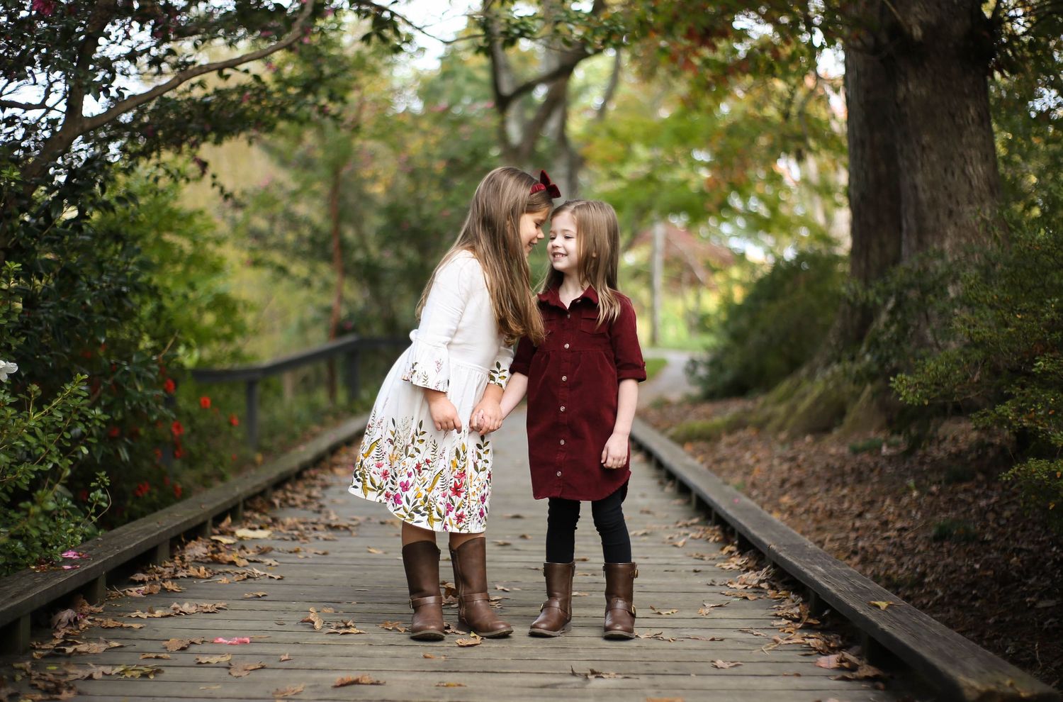 Sisters sharing a secret and magic moment on walkway in the spring at Glencarin Gardens in Rock Hill, SC.