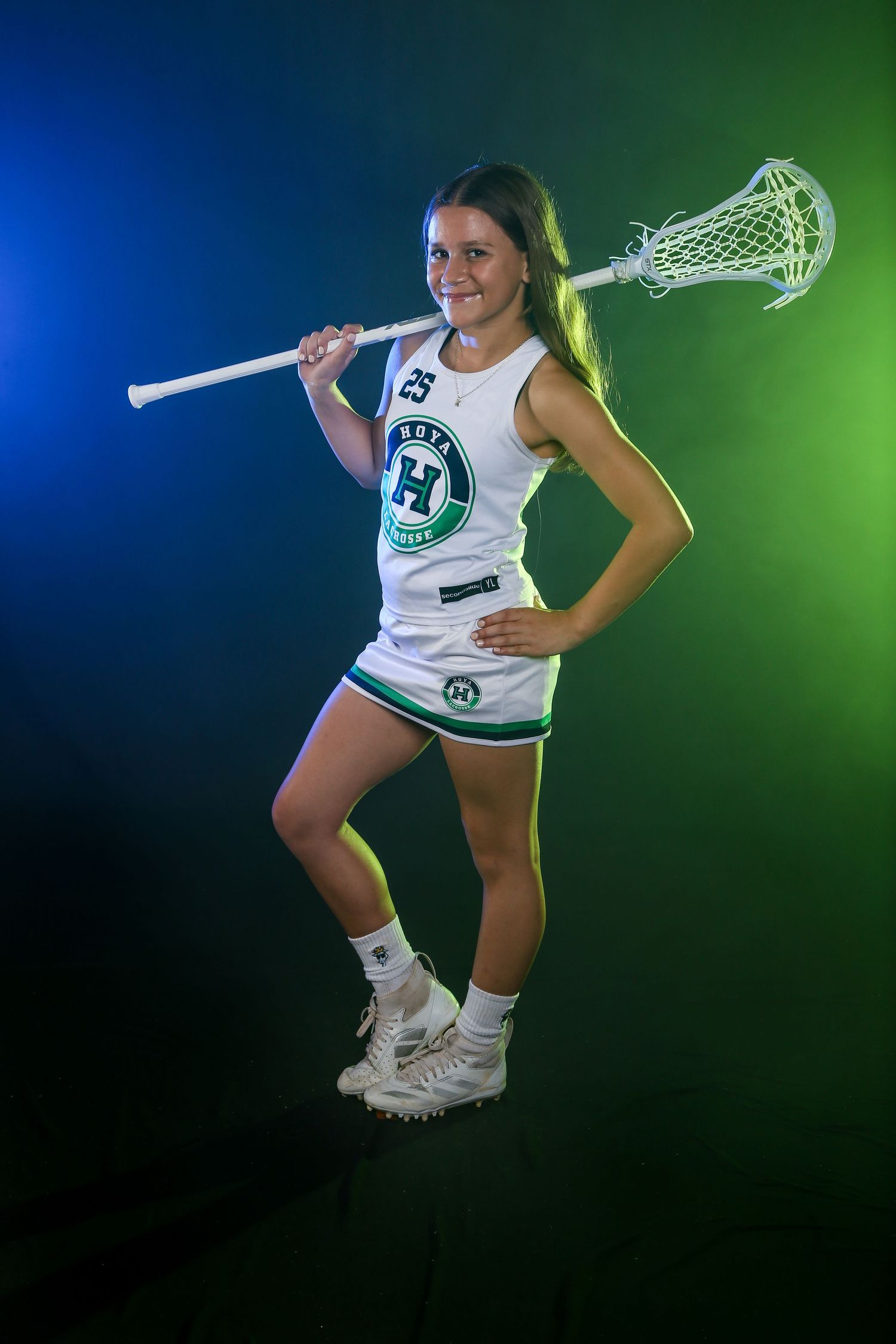 Dramatic lacrosse sports portrait, featuring colored gel lighting and smoke effects for bold, high-impact look. Girls middle school team