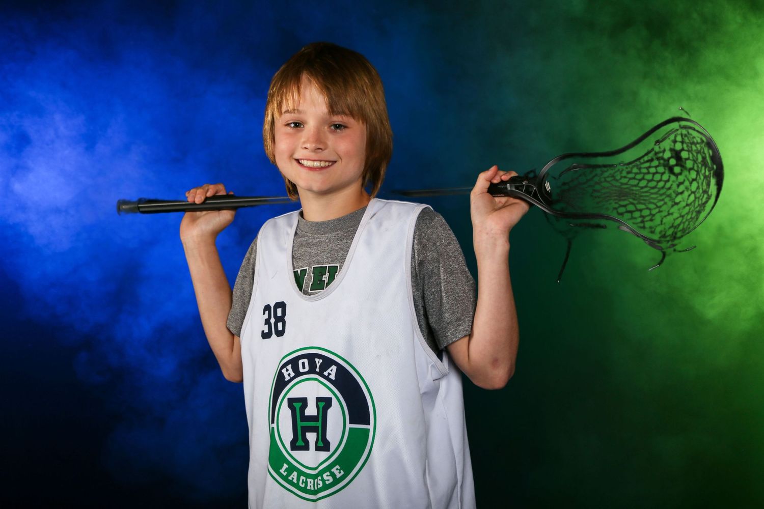 Dramatic lacrosse sports portrait, featuring colored gel lighting and smoke effects for bold, high-impact look.  Harrison High School Youth