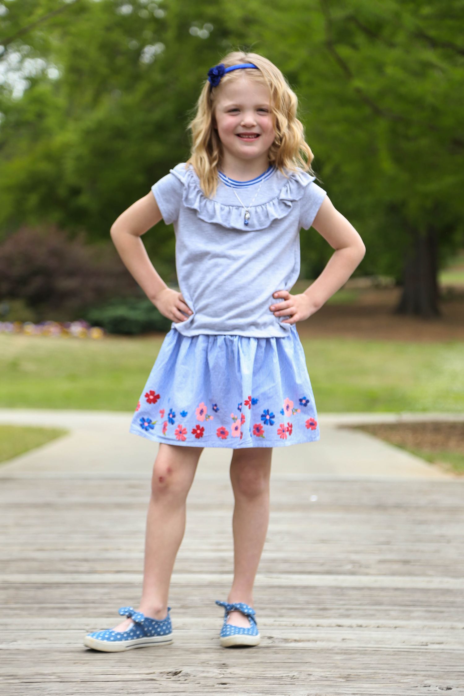Little girl poses in park.