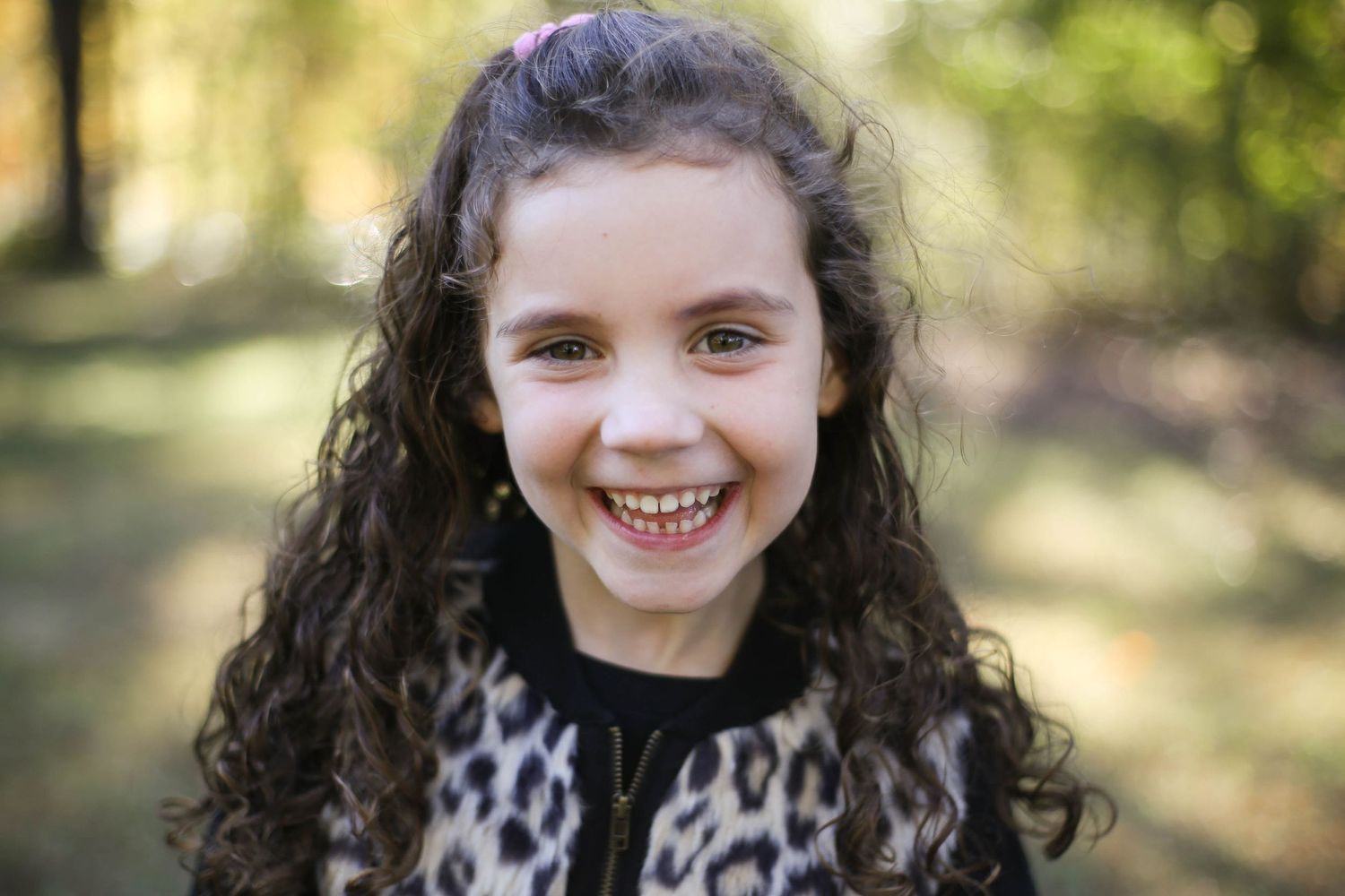 Smiling girl playing during golden hour during fall photo session at Waxhaw, NC.