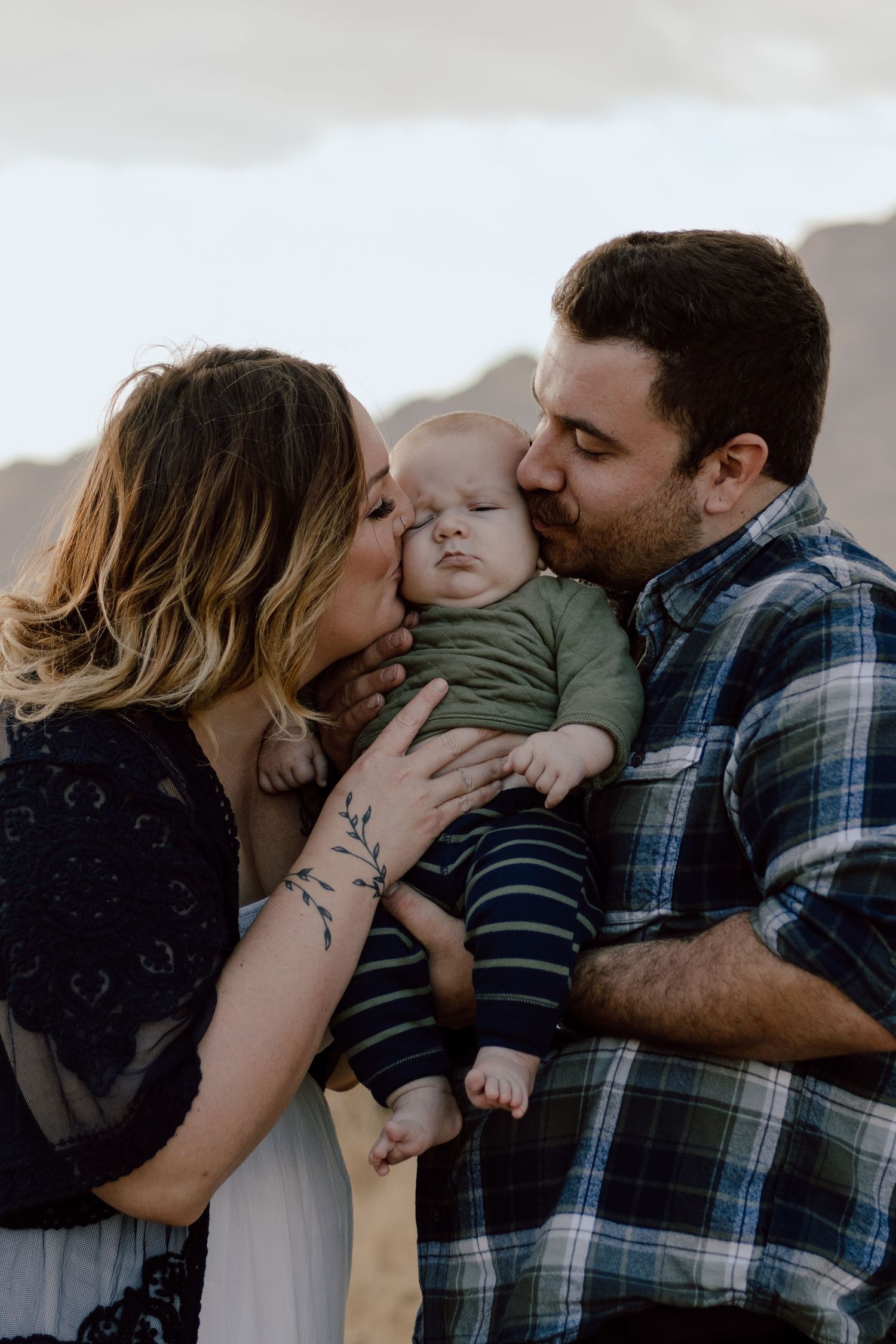 A family shares an intimate moment together against a mountain backdrop.