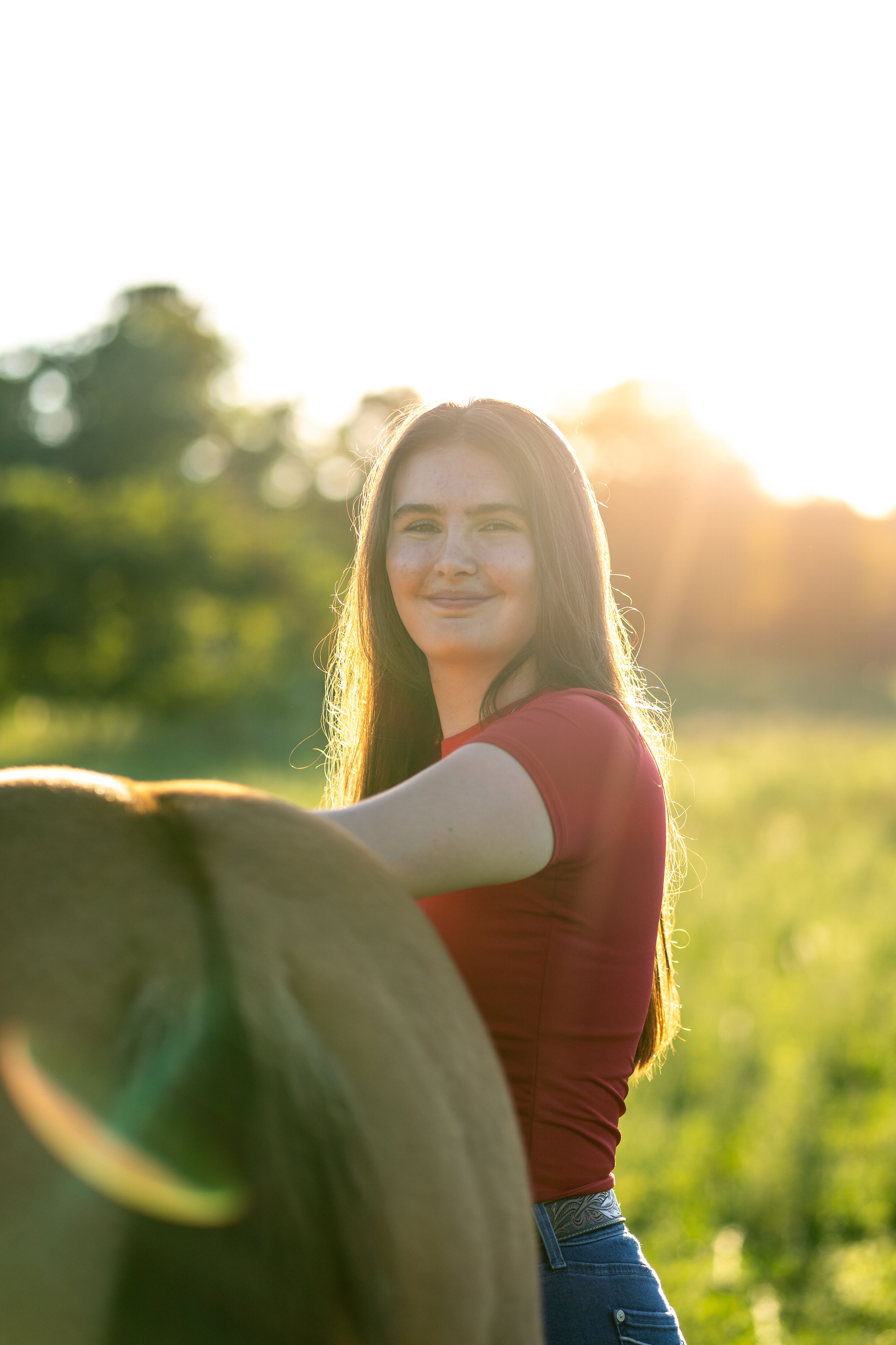 A golden backlit portrait in a field during sunset capturing a joyful summer mood.