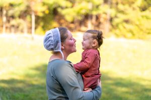 A heartwarming outdoor family moment captured in warm sunlight.