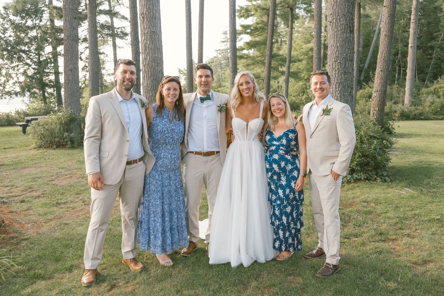 Wedding party in coordinated blue and white outfits posing outdoors.