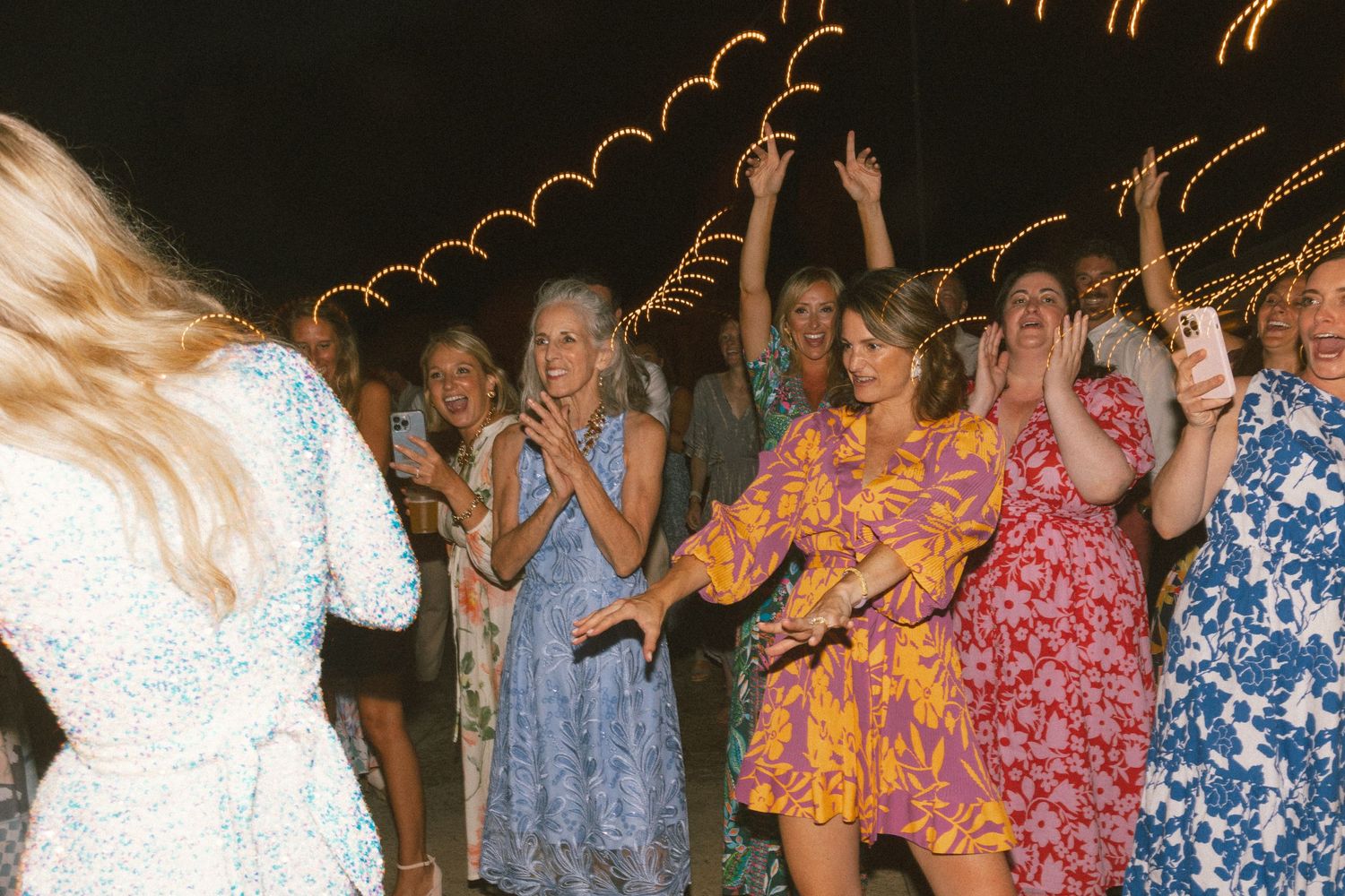 Guests dancing and celebrating at a lively nighttime wedding reception.