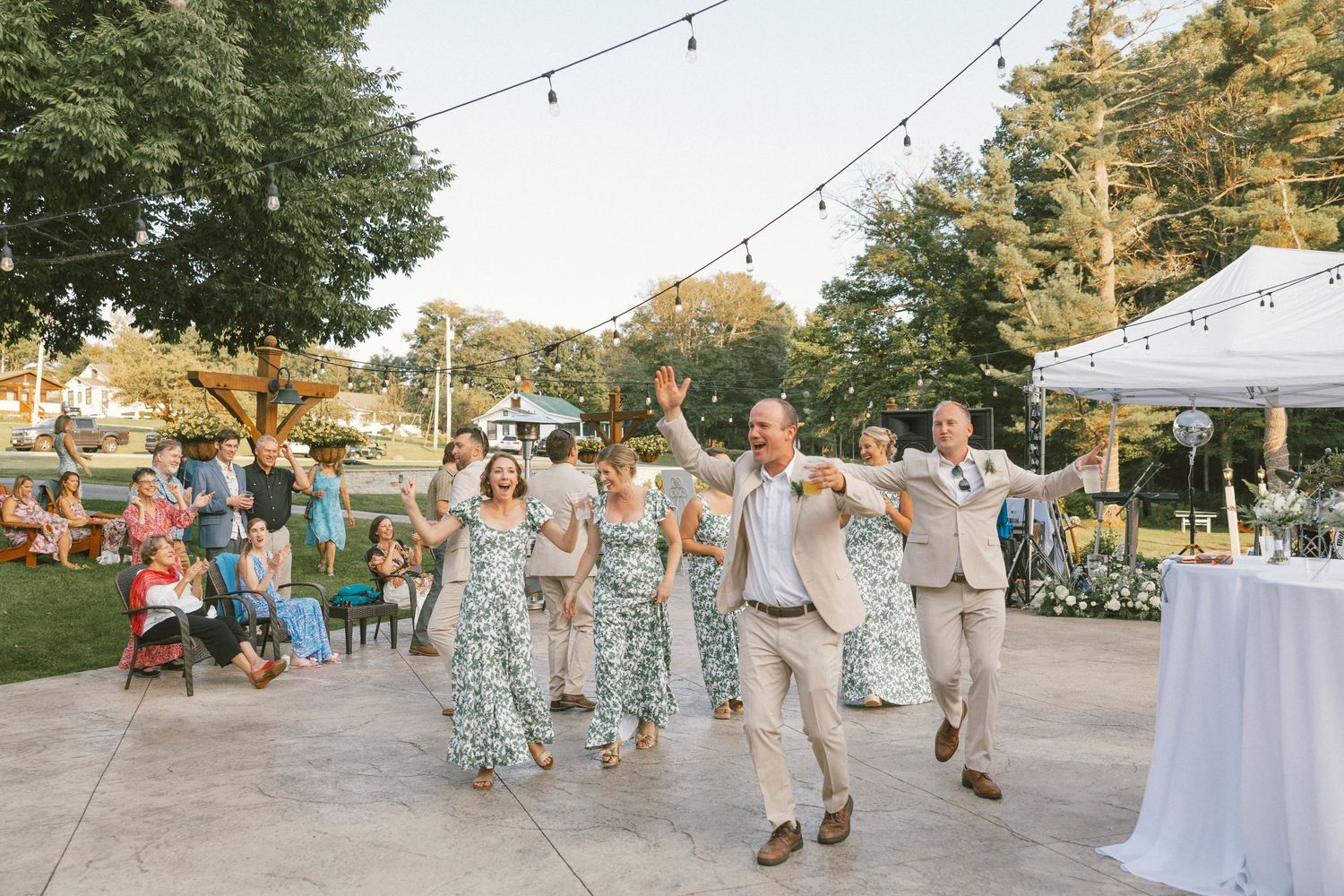 Wedding guests in coordinated outfits walking along a path at an outdoor reception.