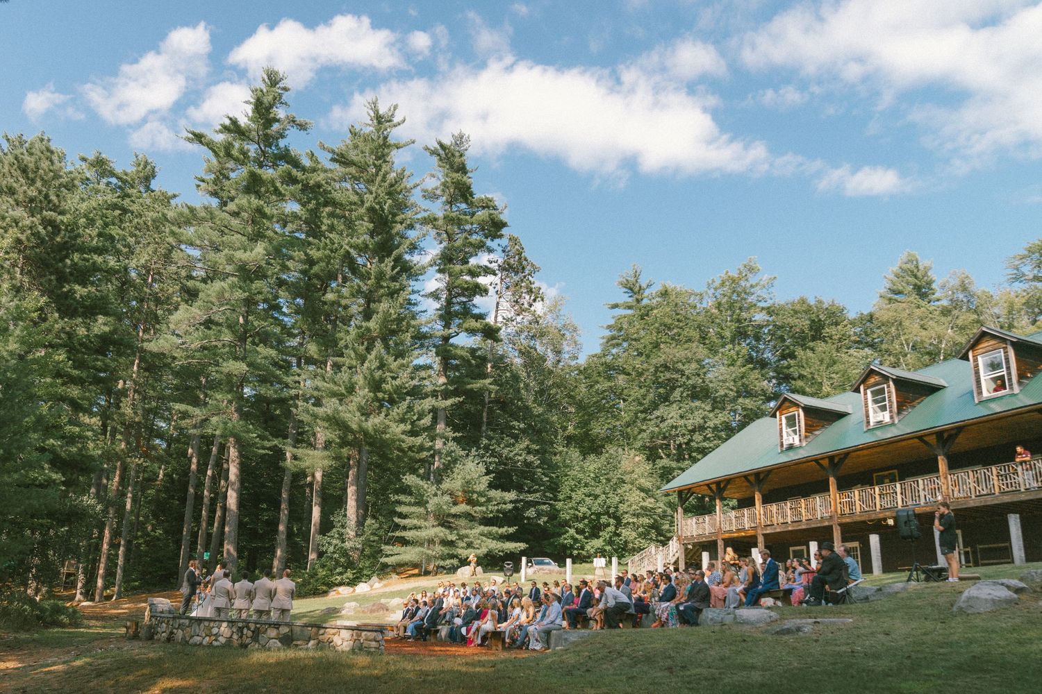Rustic lodge venue nestled among pine trees on a hillside.