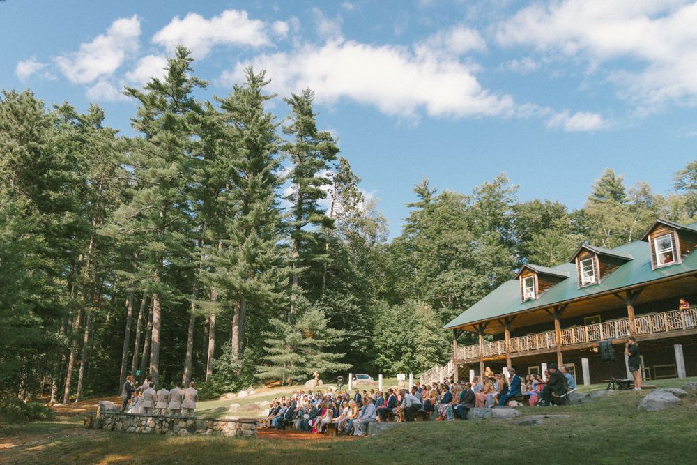 Rustic lodge venue nestled among pine trees on a hillside.